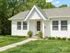 A charming front porch with wood door, fresh landscaping and white painted columns at 512 Secrest Ave, Belmont, NC 28012