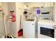 Functional laundry room with white washer and dryer and ample shelving for storage at 531 Cherry Blossom Nw Ave, Concord, NC 28027