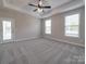 A spacious bedroom with tray ceilings, neutral walls, and a ceiling fan at 5604 Unionville Rd, Monroe, NC 28110