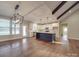 Open kitchen area with white cabinets, stainless appliances, island and hardwood floors at 5604 Unionville Rd, Monroe, NC 28110