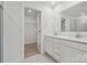 Bright bathroom featuring double sink vanity, modern lighting, and a walk-in closet at 561 Mountain View Dr, Monroe, NC 28110