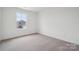 A minimalist bedroom with neutral carpet, and a window offering neighborhood views at 561 Mountain View Dr, Monroe, NC 28110