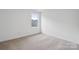 A minimalist bedroom with neutral carpet, and large window offering neighborhood views at 561 Mountain View Dr, Monroe, NC 28110