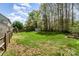 Expansive backyard featuring a lush lawn, privacy fence, and shed backing up to a treeline at 591 Highland Ridge Rd, Mooresville, NC 28115