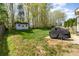 A spacious backyard with a storage shed, bordered by mature trees and a partially covered grill at 591 Highland Ridge Rd, Mooresville, NC 28115