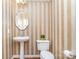 Charming powder room with striped wallpaper, pedestal sink, and toilet with a green plant at 591 Highland Ridge Rd, Mooresville, NC 28115