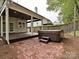 Backyard view with brick patio, wooden deck, and hot tub at 6112 Swanston Dr, Charlotte, NC 28269