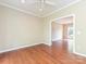 Inviting room features hardwood floors, neutral paint, a ceiling fan, and an adjacent room with natural light at 6112 Swanston Dr, Charlotte, NC 28269