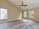 Light filled bedroom with luxury vinyl plank flooring, two windows and ceiling fan at 6112 Swanston Dr, Charlotte, NC 28269