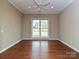 Cozy bedroom with hardwood floors, a ceiling fan, and a large window offering natural light at 6112 Swanston Dr, Charlotte, NC 28269