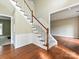 Elegant foyer boasts hardwood floors, a carpeted staircase with white railings, and neutral wall colors at 6112 Swanston Dr, Charlotte, NC 28269