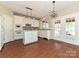 Charming kitchen with white cabinets, a center island, and modern lighting fixtures, enhanced by hardwood floors at 6112 Swanston Dr, Charlotte, NC 28269