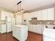 Well-lit kitchen with white cabinets, a kitchen island, and modern lighting, complemented by sleek floors at 6112 Swanston Dr, Charlotte, NC 28269