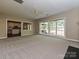 Spacious living room featuring plush carpeting, a ceiling fan, and views into the kitchen and back patio at 6112 Swanston Dr, Charlotte, NC 28269