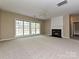 Bright living room featuring a cozy fireplace, large windows, and a ceiling fan at 6112 Swanston Dr, Charlotte, NC 28269