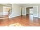 Open-concept living room with hardwood floors, adjacent dining area, and French doors to an additional room at 6112 Swanston Dr, Charlotte, NC 28269