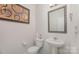 Small powder room with a pedestal sink and a framed mirror above the sink at 710 Anglin Forest Way, Charlotte, NC 28214