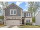 Charming two-story home features a stone and shingle facade, attached garage, and well-maintained landscaping at 710 Anglin Forest Way, Charlotte, NC 28214