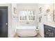Bright bathroom featuring a soaking tub with brass hardware and a large window at 728 Brookside Ave, Charlotte, NC 28203