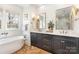 Bathroom featuring dual vanity with white countertop, dark gray cabinets, and a soaking tub at 728 Brookside Ave, Charlotte, NC 28203