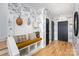 Inviting hallway featuring floral wallpaper, wood floors, and a convenient built-in bench with coat hooks at 728 Brookside Ave, Charlotte, NC 28203