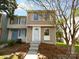 Charming two-story townhome featuring light brown siding, white trim, and manicured front yard landscaping at 7301 Pebblestone Dr # F, Charlotte, NC 28212