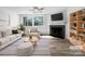 Bright living room with fireplace, large windows, ceiling fan and modern furnishings. Staged for sale at 7301 Pebblestone Dr # F, Charlotte, NC 28212
