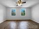 Spacious main bedroom featuring hardwood floors, a ceiling fan, and sunlit windows with green outdoor views at 7301 Pebblestone Dr # F, Charlotte, NC 28212