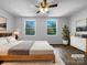 Spacious main bedroom featuring hardwood floors, a ceiling fan, and sunlit windows with green outdoor views at 7301 Pebblestone Dr # F, Charlotte, NC 28212