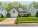 Charming two-story home with a manicured lawn, attached garage, and classic black shutters at 7353 Sedgebrook W Dr, Stanley, NC 28164