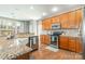Updated kitchen featuring granite countertops, stainless steel appliances, and wood cabinets at 7353 Sedgebrook W Dr, Stanley, NC 28164
