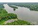Aerial view of a lake featuring a boat ramp and wooded shoreline under an overcast sky at 8225 Long Island Rd, Catawba, NC 28609