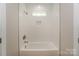 Bright bathroom features a white tiled tub with a shower and a transom window for natural light at 8225 Long Island Rd, Catawba, NC 28609