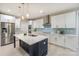 Modern kitchen showcasing white cabinets, a navy blue island, stainless steel appliances, and stylish pendant lighting at 8225 Long Island Rd, Catawba, NC 28609