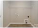 A bright, empty laundry room with tile flooring, shelving, and hookups for a washer and dryer at 8225 Long Island Rd, Catawba, NC 28609