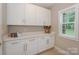 Bright laundry room with white cabinets, countertop space, and a window providing natural light at 8225 Long Island Rd, Catawba, NC 28609