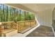 Covered patio with wood railing overlooks a wooded area with sunlight peeking through trees at 8225 Long Island Rd, Catawba, NC 28609