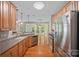 Modern kitchen with stainless steel appliances and wood cabinets open to living area at 831 Daly Cir, Fort Mill, SC 29715