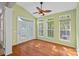 Bright sunroom with hardwood floors, vaulted ceiling, ceiling fan, and large windows overlooking the backyard at 831 Daly Cir, Fort Mill, SC 29715