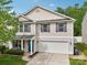 Traditional two-story home boasts neutral siding, complemented by black shutters and a covered front porch with seating at 9612 Eagle Feathers Dr, Charlotte, NC 28214