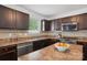 Kitchen features dark wood cabinets, stainless steel appliances, and laminate countertops with tile backsplash at 9612 Eagle Feathers Dr, Charlotte, NC 28214