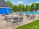 Outdoor pool area featuring tables, chairs, and a glimpse of the pool, all surrounded by lush greenery at 9612 Eagle Feathers Dr, Charlotte, NC 28214