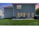 A spacious backyard featuring a patio with seating and lush green grass at dusk at 1003 Dorsey Dr, Fort Mill, SC 29715