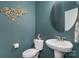 Stylish powder room in teal with gold accents, decorative wall art, and white fixtures at 1003 Dorsey Dr, Fort Mill, SC 29715