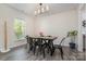 Dining room with black table and chairs, modern chandelier and large window at 1003 Dorsey Dr, Fort Mill, SC 29715