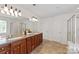 Large bathroom with dual sinks, wood cabinets, a glass enclosed shower, and a soaking tub at 10104 Silverling Dr, Waxhaw, NC 28173