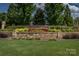 Welcoming entrance to The Chimneys of Marvin featuring stone signage and colorful landscaping at 10104 Silverling Dr, Waxhaw, NC 28173