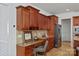 Well-appointed kitchen with granite counters, wooden cabinetry, and a built-in desk area for added functionality at 10104 Silverling Dr, Waxhaw, NC 28173
