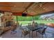 Covered patio with stone fireplace, TV, and comfortable seating area overlooking the backyard at 10104 Silverling Dr, Waxhaw, NC 28173