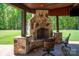 Charming outdoor stone fireplace and seating area with a peaceful backyard view at 10104 Silverling Dr, Waxhaw, NC 28173
